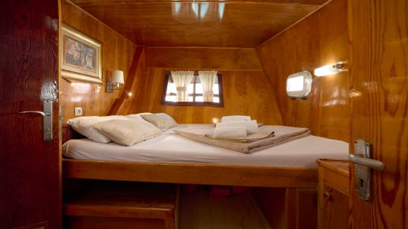 A cosy cabin on the Gulet Linda with a double bed and warm wooden walls.